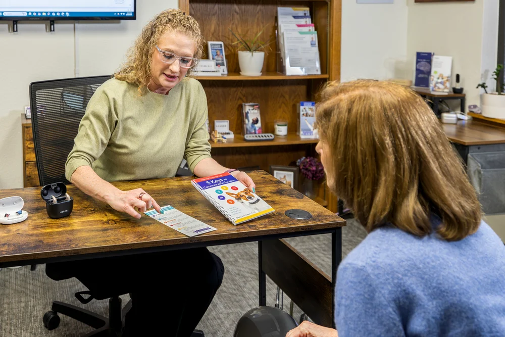 Audiologist explaining hearing aid options to a patient